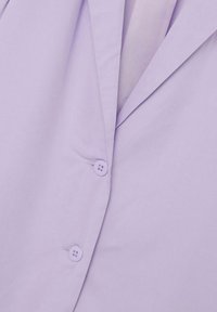 Lavendelfarbenes Hemd mit Knöpfen und glatter Textur, ausgestattet mit einem eingefassten Kragen und zwei Knöpfen an der Blende, was ein strukturiertes Designelement hinzufügt.