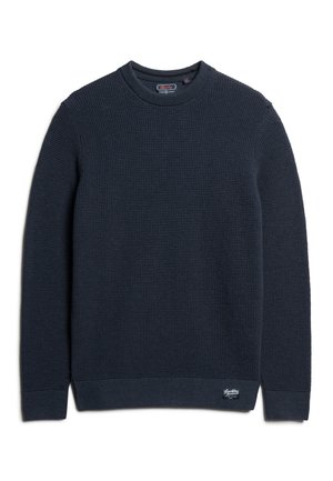 Granatowy sweter dzianinowy z teksturowanym wzorem, okrągłym dekoltem, prążkowanymi mankietami i dołem, z małą naszywką z logo w dolnym prawym rogu.