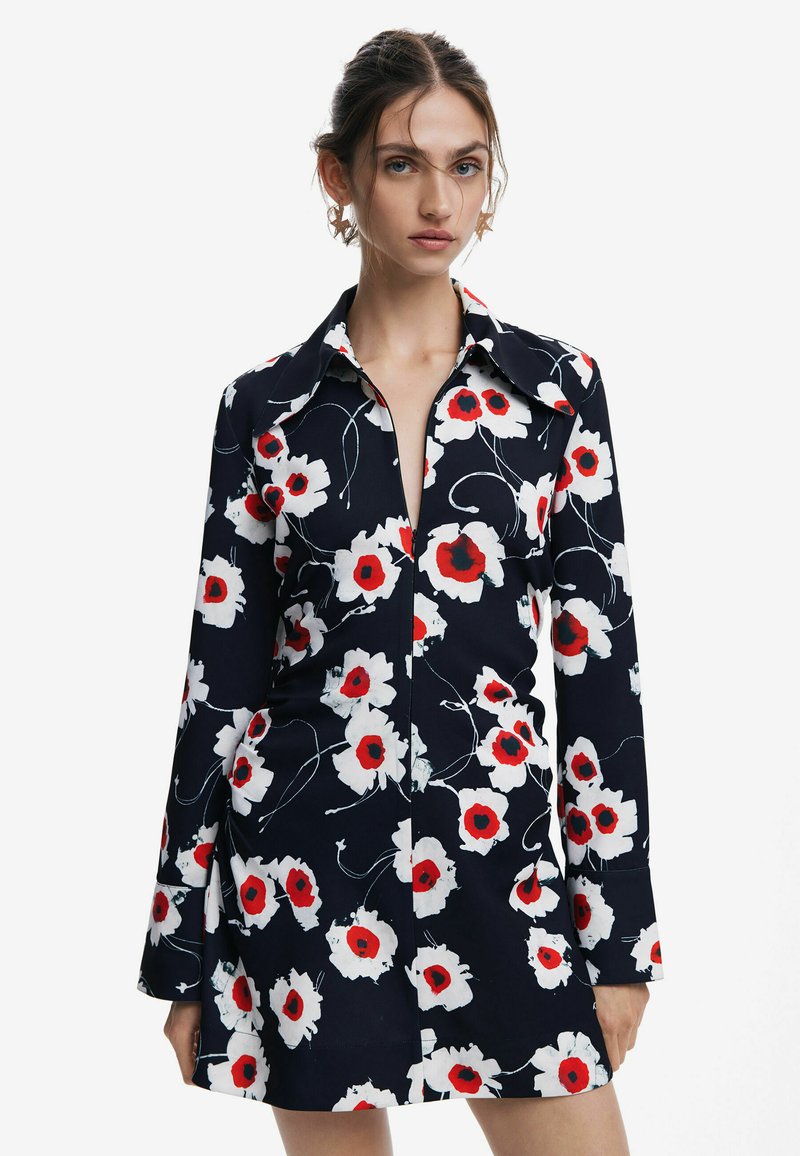 Abito floreale navy con papaveri bianchi e rossi, collo a camicia, maniche lunghe e una vestibilità sartoriale con orlo leggermente svasato.