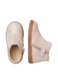 Bottines en suède rose clair avec une fermeture à glissière sur le côté et une semelle en caoutchouc beige. Texture lisse, design simple, sans motifs ou accents visibles.