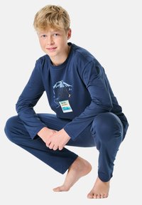 Set di pigiama blu navy a maniche lunghe in tessuto morbido, con grafica di una montagna, testo e etichetta. I pantaloni hanno una vestibilità comoda.