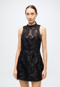 Black sleeveless dress with a fitted silhouette, featuring a sheer mesh bodice, textured floral pattern, and a belted waist.
