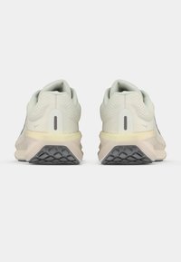 Αθλητικά παπούτσια γκρι ανοιχτού χρώματος με υφασμάτινο επάνω μέρος με υφή, εμφανή ταμπελίτσα στη φτέρνα και πολύστιφη σόλα με μαύρο λαστιχένιο πέλμα.