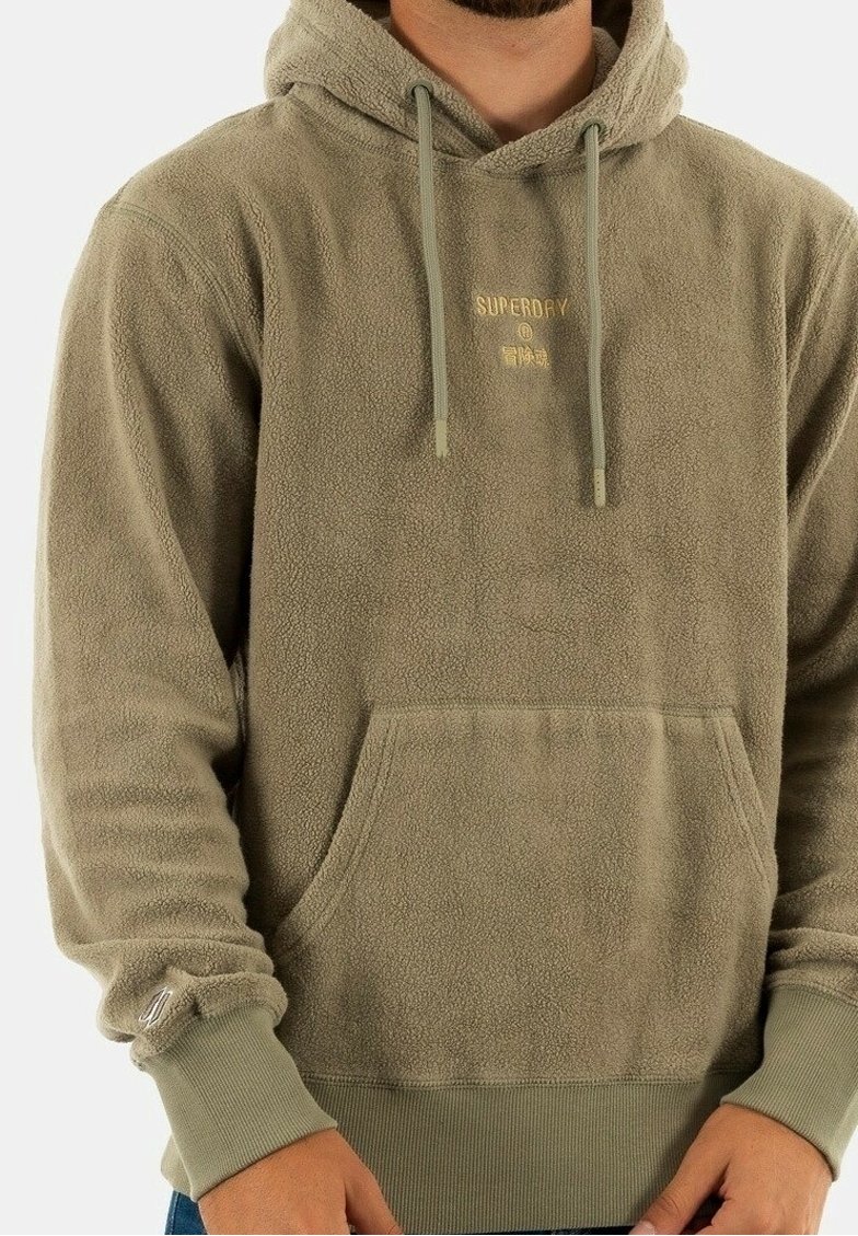 Sudadera de forro polar en verde oliva con un bolsillo canguro, puños acanalados y capucha con cordón. Presenta un pequeño logo dorado en la parte frontal.