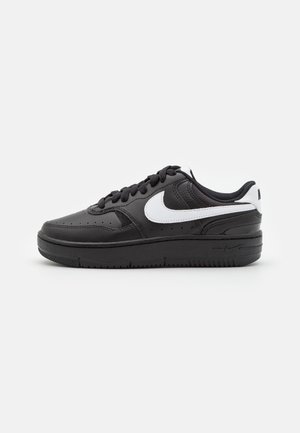 Baskets en cuir noir avec un logo Swoosh blanc, bout rond, semelle arrondie et lacets noirs. Présente un design perforé sur la boîte à orteils.