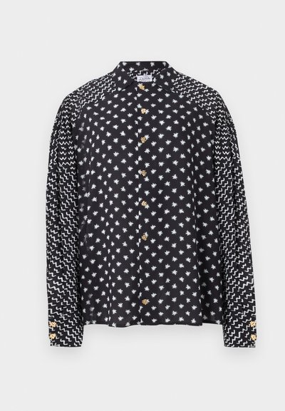 Μαύρο μακρυμάνικο πουκάμισο με λευκά αστέρι μοτίβα στο σώμα και ζιγκ-ζαγκ γραμμές στα μανίκια, με κίτρινα κουμπιά σε σχήμα λουλουδιών.