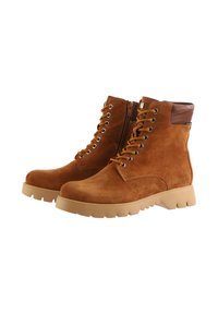 Brune ruskind ankelstøvler med en glat brun læderankelkant, snørelukning foran og en chunky beige gummisko. Har en sidelukning med lynlås.