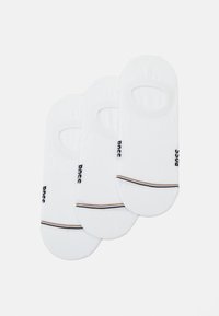 Calzini bianchi invisibili realizzati in misto cotone con aperture elastiche, dotati di logo nero e una sottile striscia marrone e nera sul tallone.