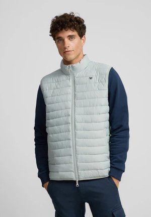 Chaleco acolchado gris claro con un cuello alto, cierre de cremallera y diseño de acolchado horizontal; acompañado de mangas en azul marino. Suave y de textura lisa.