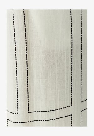 Beżowy materiał z wzorem siatki, obrysowany cienkim czarnym przeszyciem. Tekstura jest tkana, co tworzy delikatny, miękki wygląd.