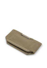 Bolso de mano de tela caqui plegada con textura acanalada y detalle de asa metálica sobre fondo blanco.