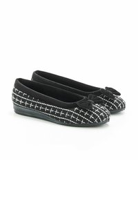 Des ballerines noires avec une tige texturée en motif damier noir et blanc, dotées d'un petit nœud décoratif sur chaque chaussure.