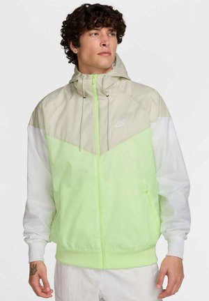 Chaqueta con capucha de Nike con un diseño ligero a bloques de color en verde claro, beige y blanco, con puños elásticos y capucha ajustable.