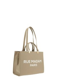 Borsa tote beige realizzata in materiale liscio, con due manici lunghi e dettagli in metallo dorato. La parte anteriore presenta un testo bianco audace: "RUE MADAM PARIS."