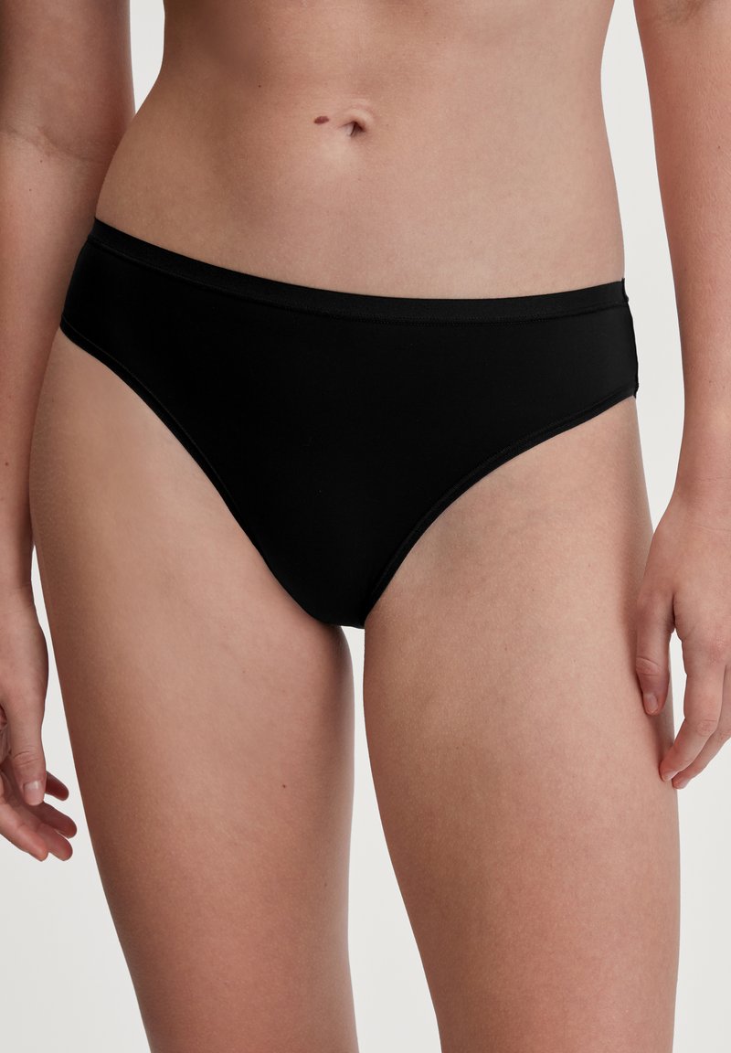 Parte inferiore di bikini nera realizzata in tessuto liscio, con vita a media altezza e design minimalista privo di motivi o elementi metallici visibili.