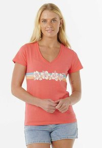 Koraalgekleurde katoenen T-shirt met een V-hals, voorzien van een bloemenontwerp en horizontale strepen in blauw, geel en oranje over de borst.
