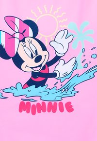 Grafik von Minnie Maus auf einem rosa Hintergrund, mit einem Wellen-Design, einer bunten Sonne und Palmenakzenten. Darunter steht der Text "MINNIE."