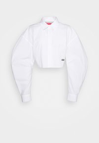 Witte, gecropt shirt met oversized mouwen, gestructureerde kraag en een logo "032" in het zwart op de voorkant gedrukt. Glad katoenmateriaal.