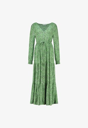 Zaļš garām piedurknēm kleita ar V-veida kakla izgriezumu, aplokšņu jostu un paisley rakstu. Iezīmējas ar savilkta svārka daļu un daudzslāņu apakšmalu, kas piešķir tekstūru.