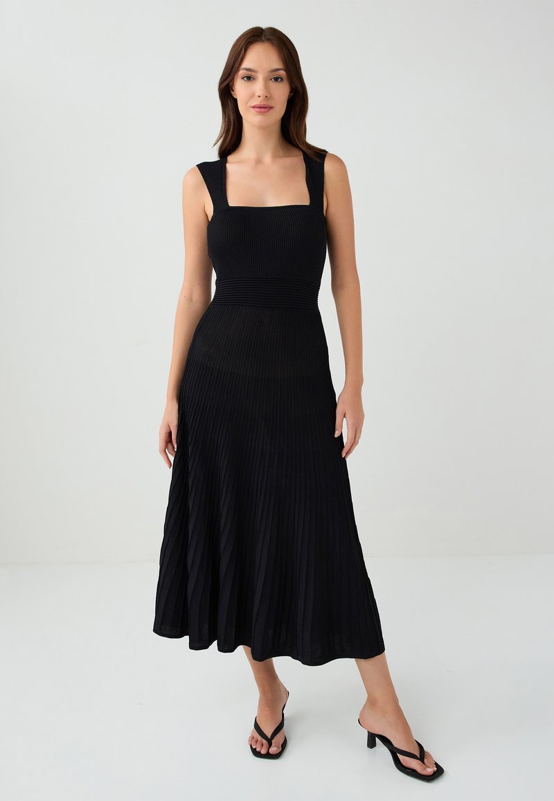 Schwarzes, plissiertes Midikleid mit quadratischem Ausschnitt, breiten Trägern und tailliertem Oberteil, das einen fließenden Rock und strukturierten Stoff aufweist.