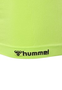 Top sportivo in tessuto a coste verde lime con logo "hummel" nero sull'orlo inferiore, caratterizzato da una vestibilità aderente e una texture liscia.
