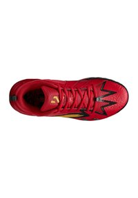 Scarpa sportiva rossa con tomaia texture, dettagli neri, motivo a zigzag, colletto imbottito e lacci. Presenta un logo dorato sulla linguetta.