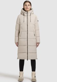 Hellbeige Pufferjacke mit Kapuze, vertikaler Steppung, Frontreißverschluss, zwei seitlichen Taschen und schwarzen Kordeln.