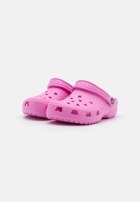 Rosa Crocs-klokker laget av lett materiale, med ventilasjonsåpninger, hevet hæl, og justerbar bakrem for sikker passform.