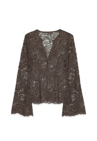 Blusa in pizzo marrone con scollatura a V, maniche lunghe a campana e motivi floreali. La texture è trasparente, creando un design intricato in tutta la superficie.
