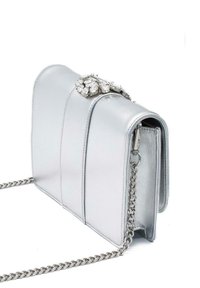 Srebrna skórzana torebka na łańcuszku, z ozdobnym zapięciem z cyrkoniami i pionowymi przeszyciami. Gładka faktura.