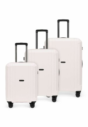 Trois valises rigides blanches avec poignées rétractables noires et quatre roues pivotantes, disposées par taille du plus petit au plus grand.