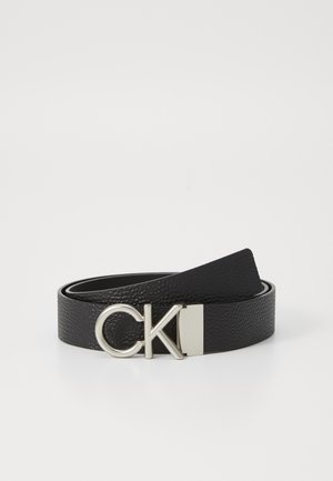 Cintura in pelle nera con finitura testurizzata, caratterizzata da una fibbia in metallo argentato con logo "CK" e una piastra rettangolare.