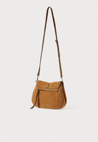 Sac en cuir suédé marron en forme courbée, avec une bandoulière en cuir ajustable, une fermeture à pression et des accents métalliques sur le rabat.