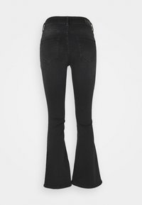 Svarta utsvängda jeans med hög midja, två bakfickor och en slät denimtextur. Benet vidgar sig ut från knäet och neråt.