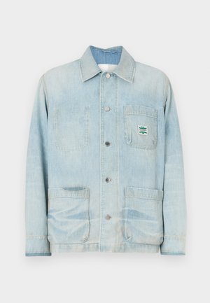 Lyseblå denimjakke med knaplukning foran, spids krave, to forlommer og et lille mærke på brystlommen.