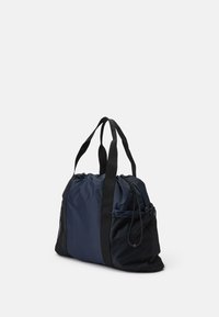 Marine nylon duffel bag med svarte stropper, rund form, gathered topp, mesh sidelomme og drasnor lukking for sikker oppbevaring.