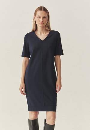 Robe bleue marine à manches courtes avec un col en V, longueur genou, en tissu lisse, présentant une coupe droite et des détails de couture subtils sur le devant.