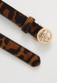 Kozene opasek s leopardím vzorem v hnědé a černé barvě, s kulatou zlatou sponou s vyříznutým logem. Hladký povrch s lesklými kovovými prvky.