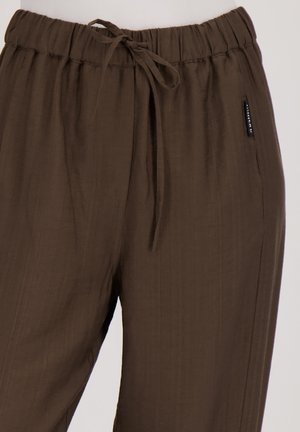 Bruine, lichtgewicht, relaxte broek met een elastische tailleband, trekkoorddetail en zijzakken. Gestructureerde stof in een subtiel patroon.