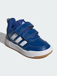 Niebieski but sportowy z trzema białymi paskami na rzep, cholewką z teksturowanej skóry oraz gumową podeszwą z brązowym wzorem na bieżniku.