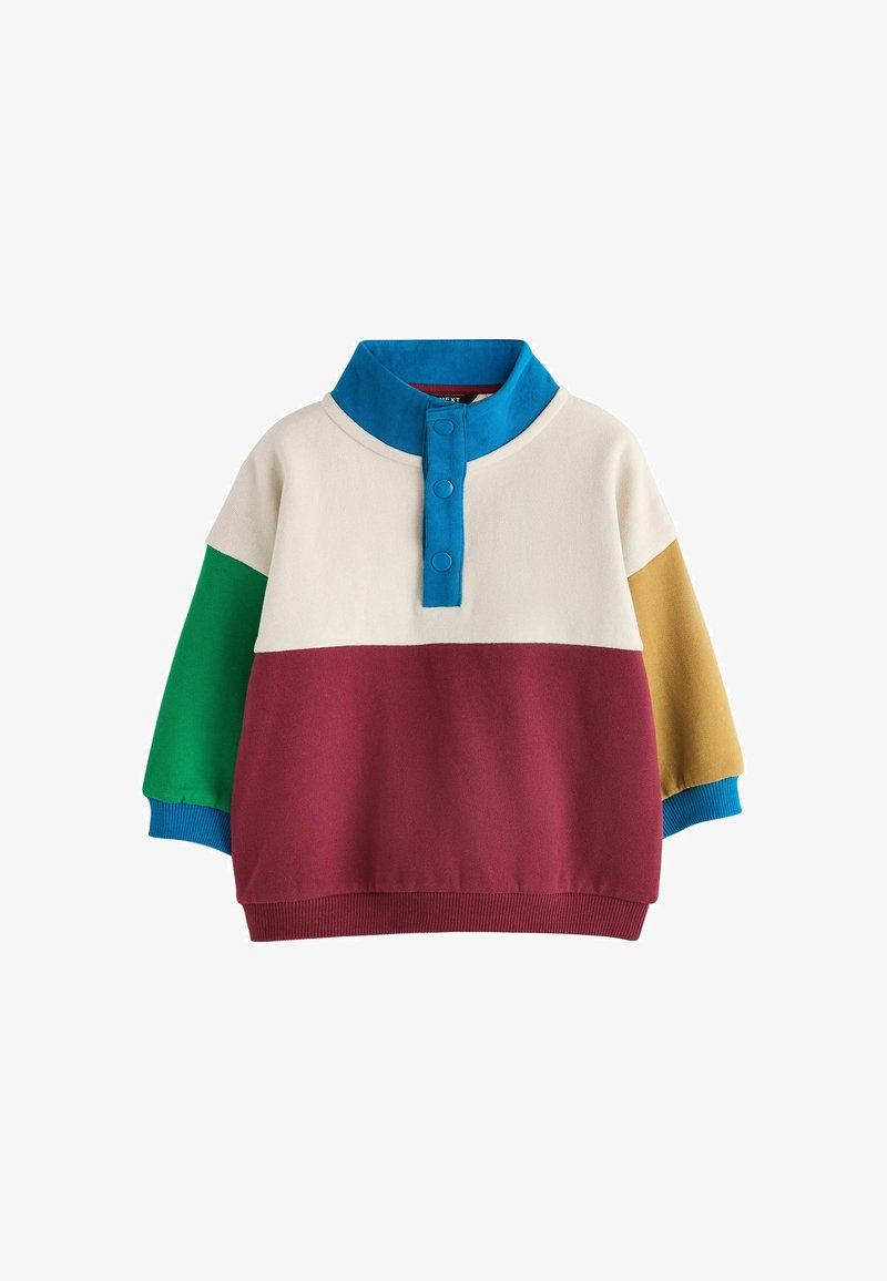 Jersey de manga larga con cuello azul abotonado, cuerpo superior beige, cuerpo inferior granate, manga izquierda verde y manga derecha mostaza con puños azules.