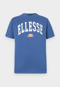 Mėlynas medvilninis marškinėlis su trumpomis rankovėmis, su ryškiu baltu "ELLESSE" užrašu ir mažyte oranžine bei mėlyna logotipu žemiau. Lygus paviršius.