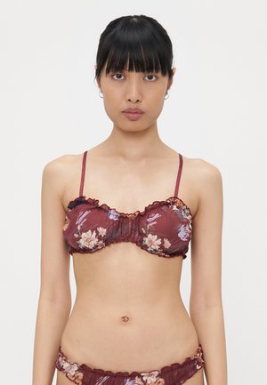 Maroon floral bikini top with ruffled edges and adjustable straps. Features a fitted design with a smooth texture and multicolored floral print.