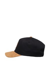 Gorra negra con visera de ante color beige. Cuenta con una corona redondeada y un pequeño parche de logo marrón en el lateral. El material textil parece suave.