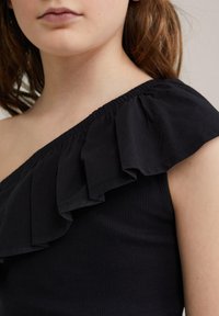 Svart topp med en axel, gjord av ribbat tyg, med en volangkrage och en figurnära design som framhäver textur och eleganta linjer.