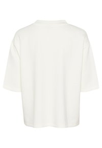 Bijela majica kratkih rukava, opuštenog kroja, s okruglim izrezom. Glatka tekstura, minimalistički dizajn, bez vidljivih logotipa ili uzoraka.