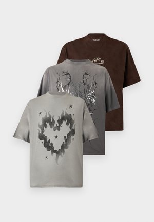 Tre T-shirts med korte ærmer i brun, grå og beige, hver med et unikt motiv: stjerner, tribal-design og hjerteformede flammer.