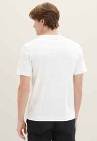 White short-sleeve t-shirt, made of soft cotton, featuring a simple crew neck and a smooth, even texture, viewed from the back.