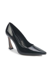 Pompe à talon aigu en cuir verni noir, à bout pointu et talon étroit et angulé, sur fond blanc.