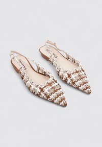 Zapatos slingback de punta afilada fabricados con material entrelazado en tonos beige y marrón, con una suela suave y una correa. Presenta sutiles acentos blancos a lo largo.